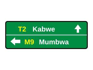 Green rectangular sign showing T2 Kabwe straight ahead and M9 Mumbwa to the left